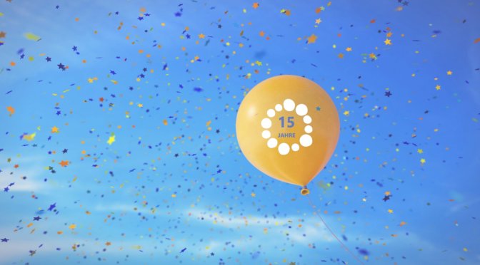 Ein gelber Luftballon fliegt in den Himmel und es regnet Konfetti