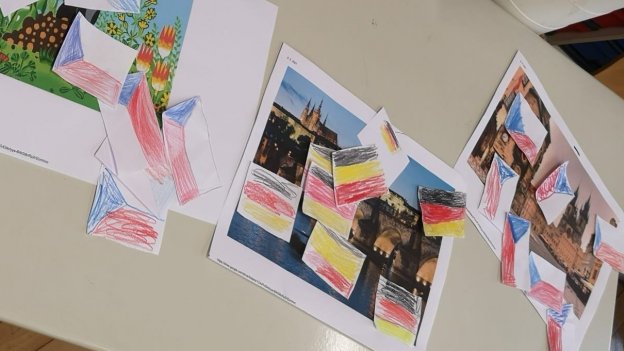 Projektfoto: die Schüler ordnen ihre selbstgebastelten Flaggen zu Fotos und vergleichen Unterschiede zwischen Tschechien und Deutschland.