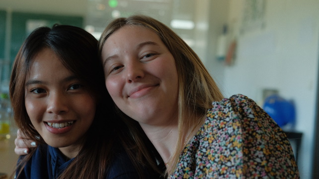Zwei Teilnehmerinnen der Abschlussveranstaltung lächeln in die Kamera.