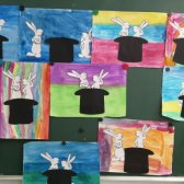 Die Schulklasse malte Papiere bunt an um Hasen eines Cartoons darauf zu kleben.