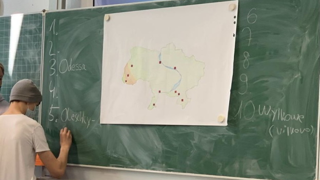 Ukrainekarte, welche von einem Schüler mit Städtenamen versehen wird.