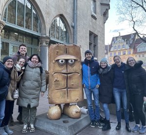 8 EmS-Aktive neben einer Skulptur von Bernd das Brot