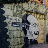 Graffiti in Kroatien. Zu sehen sind ein Mann mit einem Füllfederschreiber und einem Tuscheglas