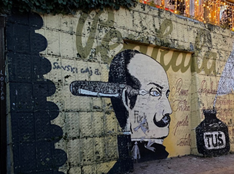 Graffiti in Kroatien. Zu sehen sind ein Mann mit einem Füllfederschreiber und einem Tuscheglas