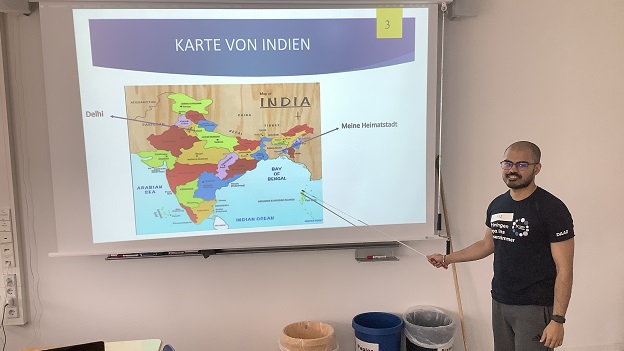 Ein indischer Student zeigt der Schulklasse auf einer Karte seine Heimatstadt 
