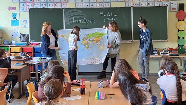 Schulklasse schauen auf eine Weltkarte im Rahmen eines EmS-Projektes