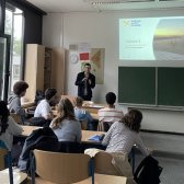 Ein EmS-Student aus Frankreich steht vor einer Schulklasse und stellt sein Heimatland vor 
