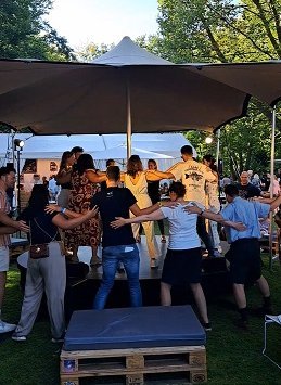 Eine Personengruppen tanzt einen Griechischen Tanz auf der Aktionsbühne