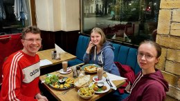Drei junge Menschen sitzen in einem Restaurant gemeinsam an einem Tisch