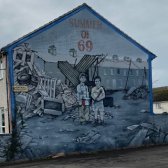 Haus in Belfast, bemalt von Straßenkünstler:in mit Motiv passend zu Nordirland-Konflikt