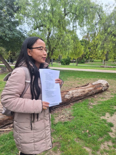 Eine Person im Park mit einem Blatt Papier in der Hand
