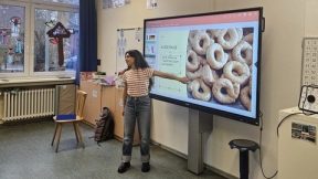 Bild von einer italienischen Studentin, wie sie auf einer Präsentation der Schulklasse italienisches Gebäck zeigt.
